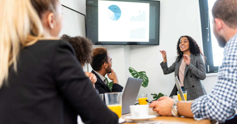 Young woman presenting data to convince stakeholders during a business meeting at the office