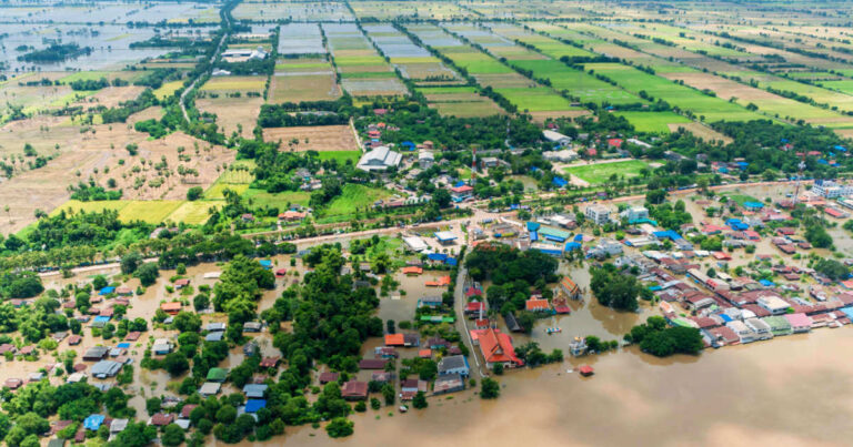 Flood disaster with water covering the streets, houses, and agricultural fields of a town